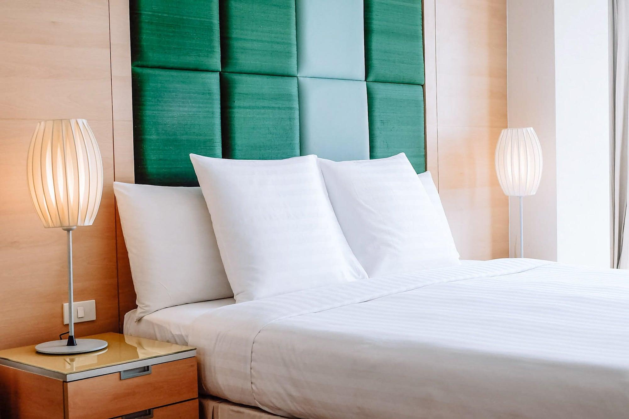 Urbana Langsuan Hotel Bangkok Luaran gambar A bed with a green headboard